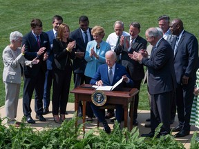 U.S. President Joe Biden signs an executive order after delivering remarks on the steps his Administration is taking to strengthen American leadership on clean cars and trucks on the South Lawn of the White House.