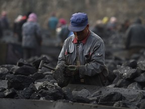 A worker sorting coal on a conveyer belt, near a coal mine at Datong in northern China's Shanxi province.