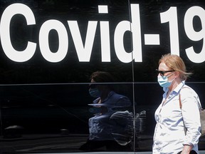 A woman wearing a mask passes by a coronavirus disease mobile testing van in New York City, as cases of the infectious Delta variant of COVID-19 continue to rise.