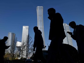 People walk past skyscrapers in the central business district in Beijing. A 32-year-old Chinese venture capitalist collapsed and died this week after a gruelling life coaching session.