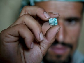 An Afghan miner examines an emerald from a makeshift emerald mine in The Panjshir Valley on July 14, 2010.