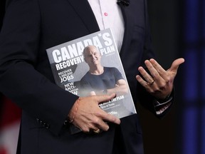 rin O'Toole holds the Conservative Party's magazine featuring his recovery plan during a campaign event in Ottawa.