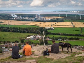 Walkers look out from Helsby Hill across the Mersey Estuary towards the CF Industries Holdings Inc. fertilizer manufacturing complex, which is being forced to be shut down due to high natural gas prices, in Ince, U.K.