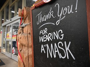 A sign outside a supermarket in Indian Valley, California, asks patrons to wear a mask. Fear of the fast spreading Delta variant of COVID-19 and rising prices undermined Americans' confidence in August.