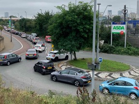 An aerial view shows customers queueing in their cars to access an Asda petrol station in east London on September 25, 2021.