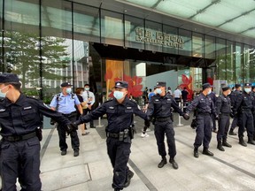 Security personnel form a human chain as they guard outside the Evergrande's headquarters, where people gathered this week to demand repayment of loans and financial products, in Shenzhen, Guangdong province, China.