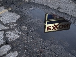 Exxon Mobil Corp. signage is reflected in a puddle at a gas station in Nashport, Ohio, U.S.