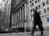 A man walks past the New York Stock Exchange on Wall Street in New York City.