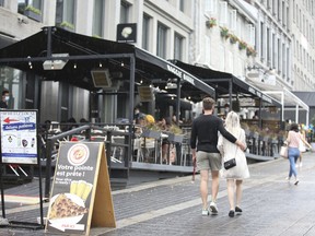 People walk past an outdoor restaurant in Montreal on June 5, 2021.