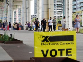 People line up outside a polling station to vote in the federal election, in Toronto, Sept. 20, 2021.