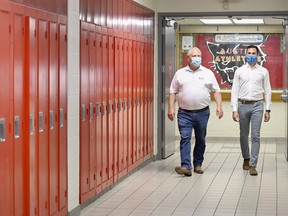 Ontario Premier Doug Ford, left, and Education Minister Stephen Lecce walk a hallway at Father Leo J .Austin Catholic Secondary School in Whitby, Ont.