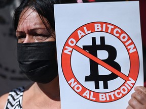 A woman holds a banner that reads "No to bitcoin" during a demonstration against the circulation of bitcoin in San Salvador, on Sept. 7, 2021.
