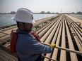 An employee looks out over oil transport pipelines on the Arabian Sea in Saudi Aramco's Ras Tanura oil refinery and oil terminal in Ras Tanura, Saudi Arabia.