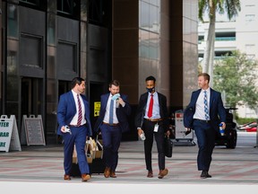 Pedestrians walk outside the Palm Beach County Courthouse in West Palm Beach, Florida. Wall Street firms are expanding in South Florida.