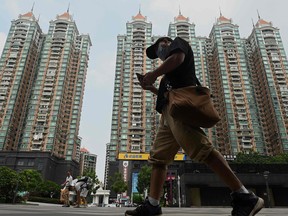 A man walks past a housing complex by Chinese property developer Evergrande in Guangzhou, China's southern Guangdong province.