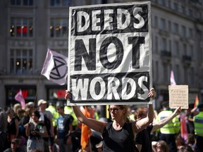 Demonstrators hold placards during an Extinction Rebellion climate activists' protest, at Oxford Circus, in London, Britain, August 25, 2021.