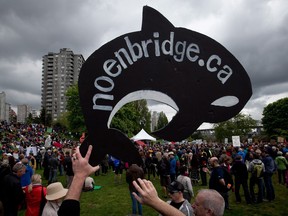 A protester holds up a sign shaped like an orca whale during a demonstration against the Enbridge Northern Gateway Pipeline in Vancouver, B.C., on Saturday May 10, 2014.
