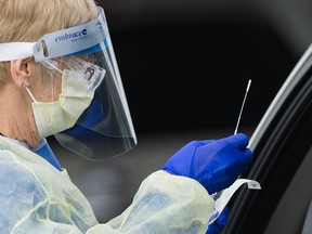 A health-care worker does testing at a drive-thru COVID-19 assessment centre at the Etobicoke General Hospital in Toronto on April 21, 2020.
