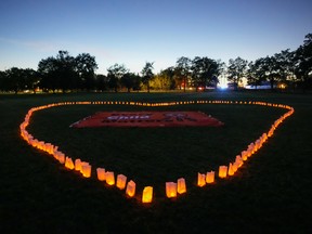 Candles forming a heart shape around a banner during a vigil on Canada's first National Day for Truth and Reconciliation at Chiefswood Park in Ohsweken, Ont., Sept. 30, 2021.