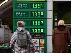 Pedestrians walk past a gas station in Paris on Oct. 2, 2021, as the price of oil increased in all Europe.