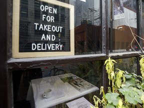 A sign for takeout and delivery inside a restaurant in Toronto on Nov. 13, 2020.