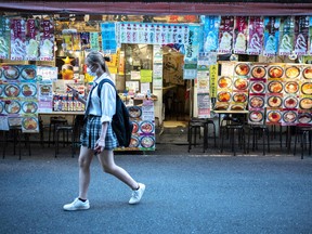 A woman walks past a restaurant in Tokyo on Oct. 5, 2021.
