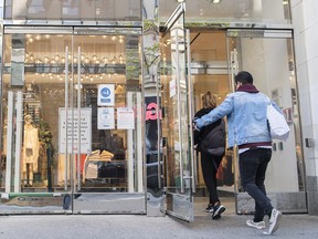 Shoppers enter a clothing store on Sainte-Catherine street in Montreal on Oct. 6, 2021.
