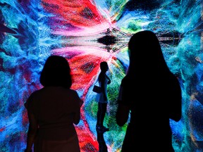 Visitors in front of an immersive art installation titled 'Machine Hallucinations - Space: Metaverse' by media artist Refik Anadol, which will be converted into NFT and auctioned online at Sotheby's, at the Digital Art Fair, in Hong Kong, China on Sept. 30, 2021.