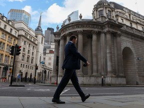An office worker passes the Bank of England in the City of London, U.K., on Oct. 20, 2021.
