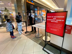 A security guard checks for proof of vaccination at the entrance to a food court in Toronto on Sept. 22, 2021.