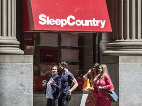 Pedestrians walk past a Sleep Country Canada location in Toronto on June 19, 2018.