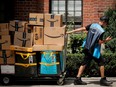 An Amazon delivery worker pulls a delivery cart full of packages during its annual Prime Day promotion in New York City, U.S., June 21, 2021.