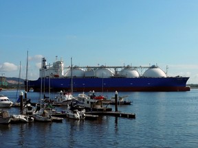 An LNG tanker passes boats along the coast of Singapore.