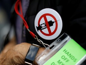 A man wears an anti-vaccine button at a protest.