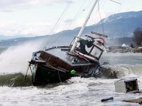 A sailboat crashes in heavy waves against a beach near English Bay after rainstorms lashed the western Canadian province of British Columbia in Vancouver, November 15, 2021.