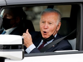 U.S. President Joe Biden gestures after driving a Hummer EV during a tour at the General Motors 'Factory ZERO' electric vehicle assembly plant in Detroit, Michigan this month. His bill would give U.S. consumers a tax credit of up to US$12,500 if they purchase an electric vehicle made in the U.S. by union workers.