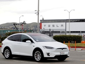 A Tesla vehicle drives past Tesla's primary vehicle factory in Fremont, California on May 11, 2020.