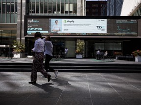 Pedestrians pass in front of the Toronto Stock Exchange in the financial district of Toronto on Sept. 16, 2021.