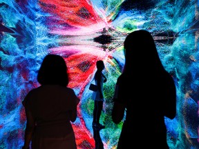 Visitors in front of an immersive art installation titled 'Machine Hallucinations - Space: Metaverse' by media artist Refik Anadol, which will be converted into NFT and auctioned online at Sotheby's, at the Digital Art Fair, in Hong Kong, China on Sept. 30, 2021.