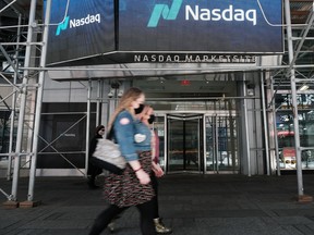 People walk by the Nasdaq Composite site in Times Square on May 11, 2021 in New York City.