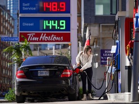 A woman fills her vehicle with fuel during the COVID-19 pandemic in Toronto on Oct. 19, 2021.