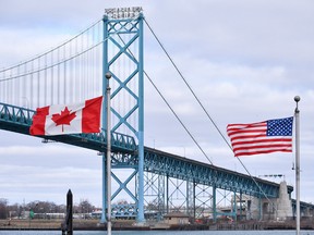 Canadian and American flags fly near the Ambassador Bridge at the Canada-USA border crossing in Windsor, Ont. on March 21, 2020.
