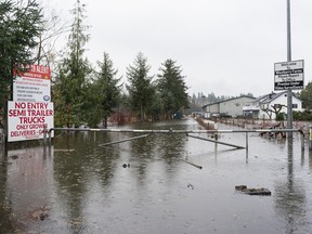 The entrance to a blueberry farm is blocked by rising flood waters on Nov. 18, 2021 in Abbotsford, B.C.