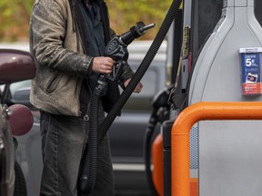 A customer holds a fuel pump nozzle at a 76 gas station in San Francisco, California, U.S., on Monday, Nov. 15, 2021.