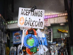 A sign that reads "We accept bitcoin here" is seen outside a street stall in Sal Salvador, on November 18, 2021.