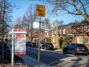 A for sale sign is displayed outside a home in Toronto, Ontario in Toronto, Ontario, Canada December 13, 2021.