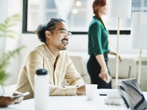 Smiling businessman in discussion with colleagues while working on project in office