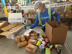 Toronto Daily Bread Food Bank volunteers package goods into boxes destined for the needy last month. DBFB officials said demand is up 30 per cent this year.