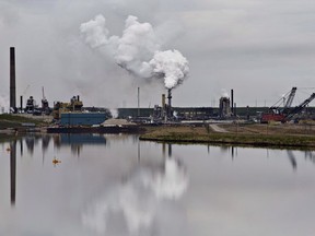 The Syncrude oil sands extraction facility is reflected in a tailings pond near the city of Fort McMurray, Alberta on June 1, 2014.