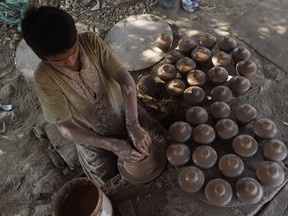 A Pakistani child potter makes earthen piggy banks at a workshop in Karachi on Jan. 14, 2019.